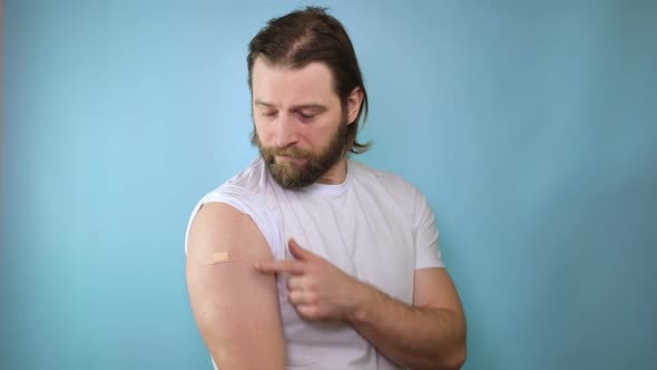 Smiling Adult Caucasian Man Show Shoulder with Aid After COVID Vaccine alt