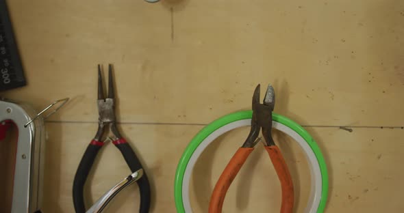 Diverse tools and belts hanging on wall in leather workshop alt