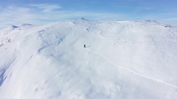 Skier surviving the cold of Hamlagro Bergsdalen Norway - Climbing up snowy hill to reach mountain to alt