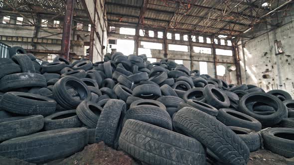 Black junk tires lying on the floor in the old abandoned building. alt