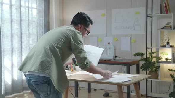 Back View Of A Man Designer Arranging The Bag Sketching Layout Bond At The Office alt