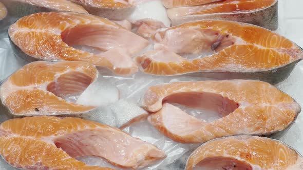 Close Up Footage of Freshest Pieces of Salmon Lie on Crushed Ice on the Counter There is Cold Steam alt