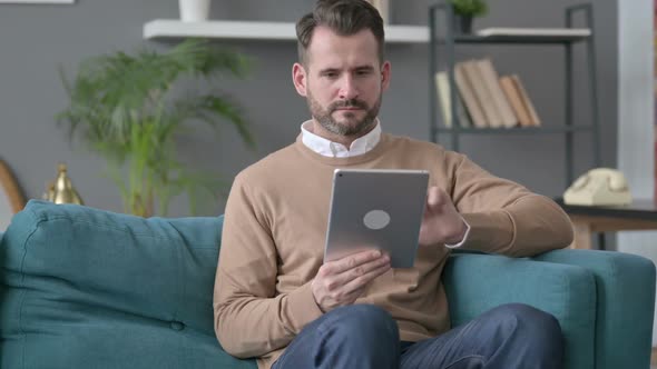 Man Using Tablet on Sofa alt