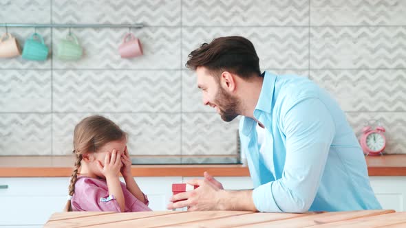 Father giving a birthday present to his daughter at home alt