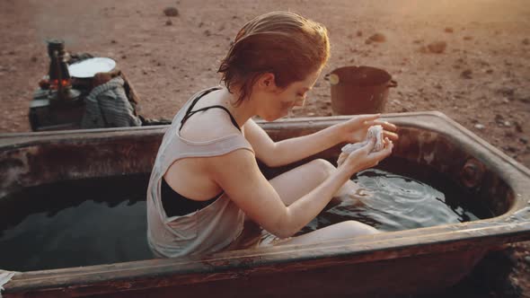 Woman Washing in Dirty Bath in Post Apocalyptic World alt