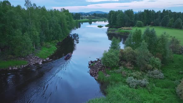 Aerial view of a small boat sailing a river in Overtornea, Sweden. alt