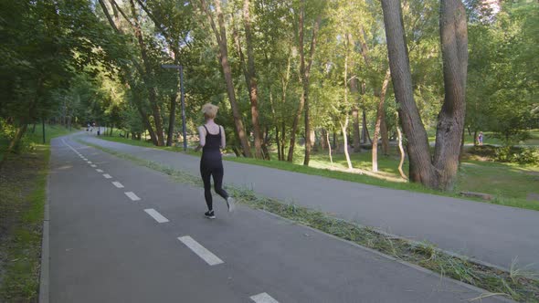 Back View in Full Length Caucasian Slender Strong Active Motivated Woman Blonde Jogger Runner with alt