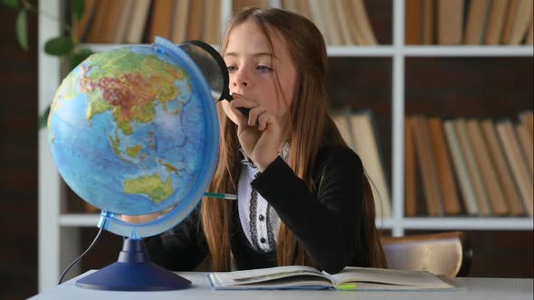 Student Child Studying Earth Globe in Library. Child in School Class. Kid learning