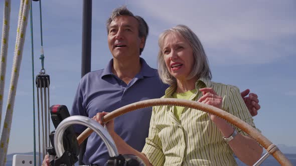 Senior couple behind the wheel of sailboat together. Shot on RED EPIC for high quality 4K, UHD, Ultr alt