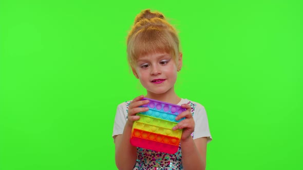 Child Girl Kid Loses on Mobile Phone Game Use Squishy Silicone Antistress Pop It Toy to Calm Down alt