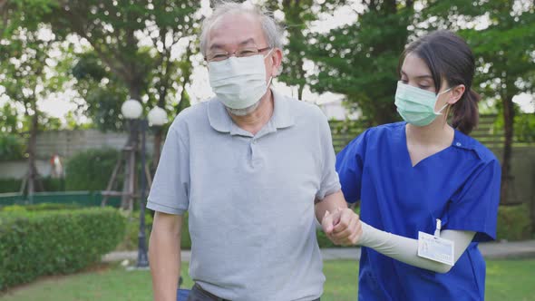 Asian young woman nurse at nursing home take care and support disabled senior elderly man on walker alt