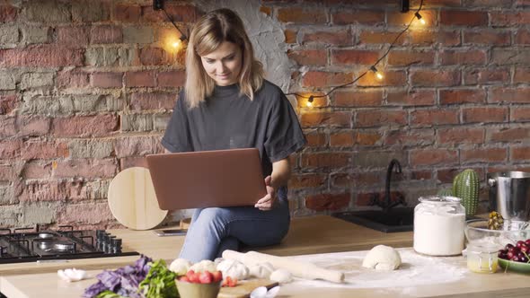Businesswoman in Tshirt and Denim Jeans Types on Laptop