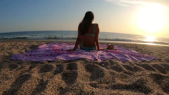 Young woman in bikini watching sunset by the seashore and taking a bath alt