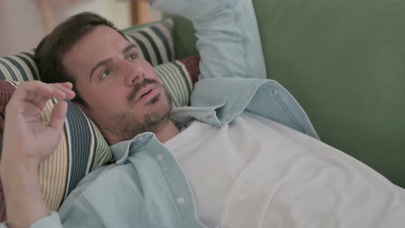 Tense Young Man Lying on Sofa in Stress Close Up alt
