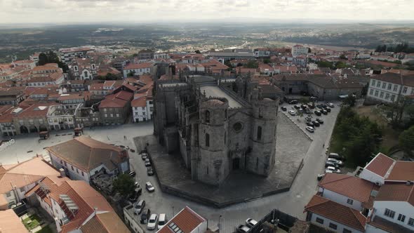 A monumental gothic cathedral captured from the air on a sunny day. Guarda, Portugal