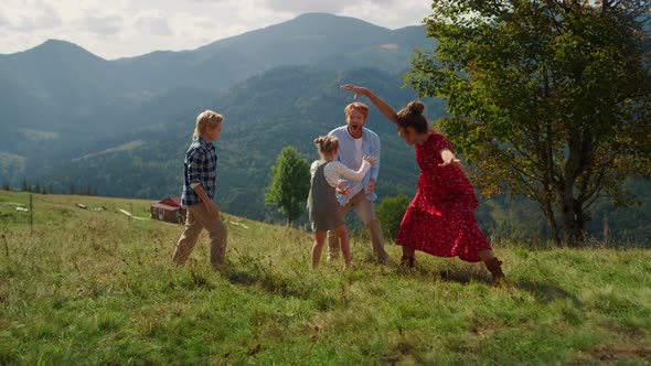 Playful Family Fooling Playing on Hill Summer Day alt