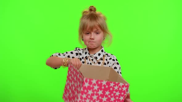Child Girl Unwrapping Birthday Gift and Expressing Disappointment Dislike Bad Present Dissatisfied alt