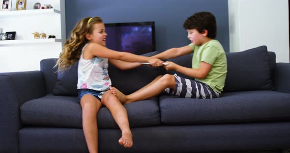 Siblings having fun in living room alt