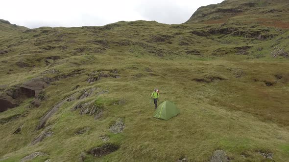 Hiker aerial view hiking in the hills and sleeping in a tent alt