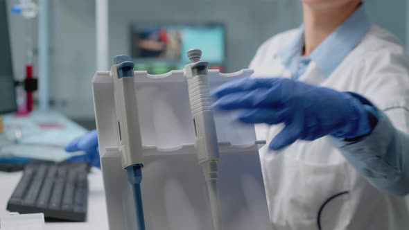 Close Up of Biochemist Using Micropipette in Laboratory alt
