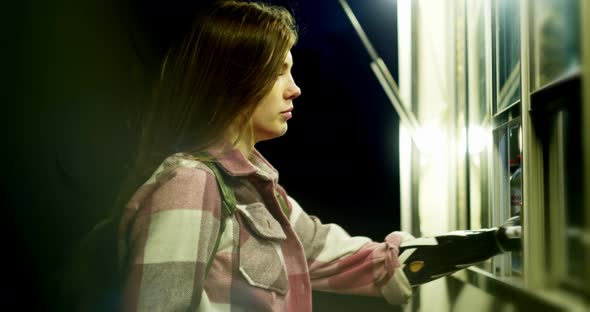 Disabled Person with a Bionic Arm Takes a Disposable Cup of Coffee From the Counter alt