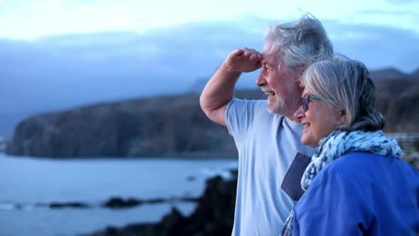 couple of two cute seniors together enjoying summer and having fun at the beach looking at the sea alt