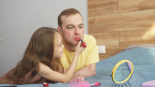 Cheerful Girl Applying Makeup at Father's Face