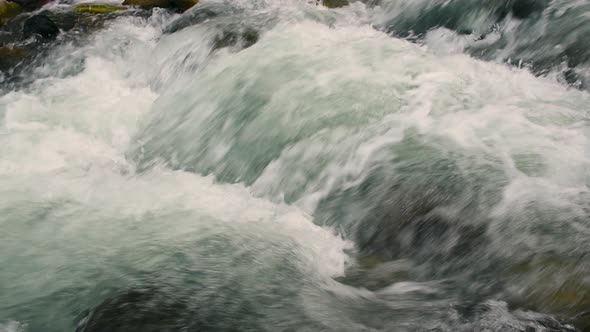 Close up of river stones with flowing water, clean water flowing in a mountain river