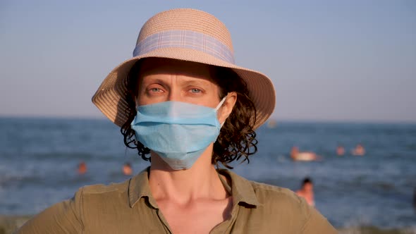 Portrait of beautiful woman in panama wearing disposable mask. Epidemic contagious virus 