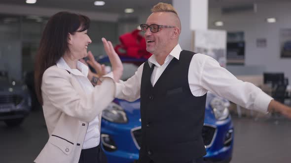 Excited Adult Couple Rejoicing Car Winning in Dealership in Slow Motion alt