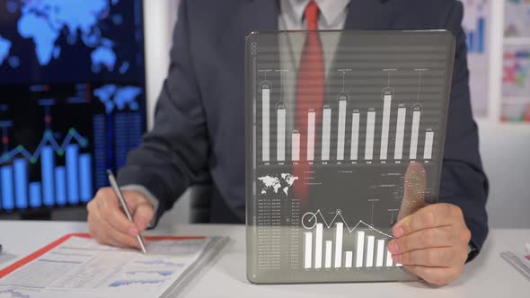 Businessman In Office Looking Charts 