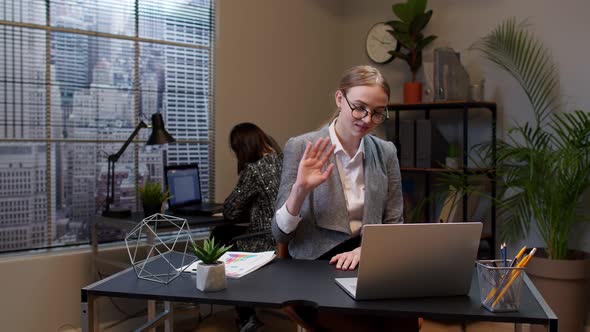Focused Businesswoman Waving Hand Hi Hello Bye Talking Looking Into Laptop Computer at Home Office alt