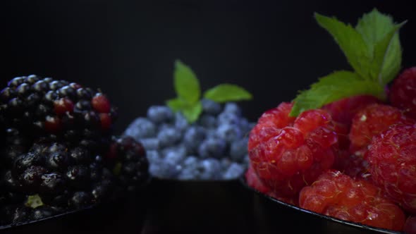 Bowls full of fresh forest fruits and leafs of mint. Probe lens footage.