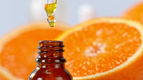 Super Slow Motion Shot of Oily Orange Essence Drop From Dropper Into Phial at 1000Fps alt