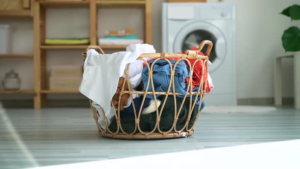 Prepared Basket with Dirty Casual Clothes on Floor of Bathroom with Washing Machine alt