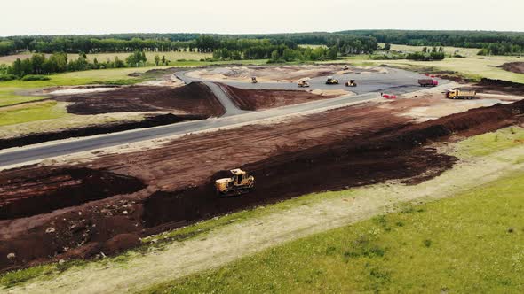 Aerial View of Big Trucks and Cars That are Building Roads for Testing Ground for Cars alt