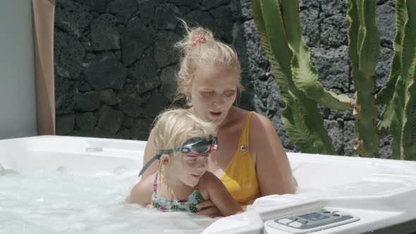 Mother and little daughter relaxing and having fun in spa bath, Stock Footage