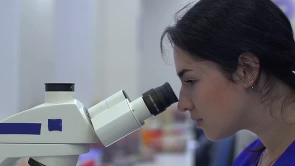 Lab Technician Looking in Microscope alt