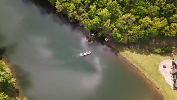 This is a slow shot of a boat coming to shore from a drone. It is shot in a beautiful part of Arkans alt