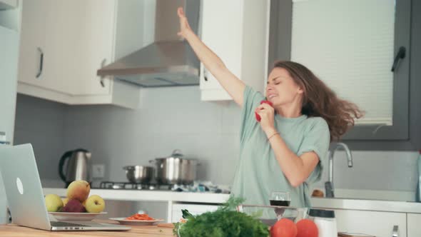 Young Caucasian Cheerful Woman Having Fun While Cooking in the Kitchen alt