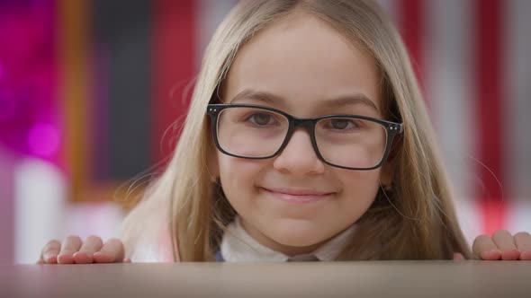 Closeup Smiling Joyful Teen Girl Emerging at Desk in School Classroom Looking at Camera alt