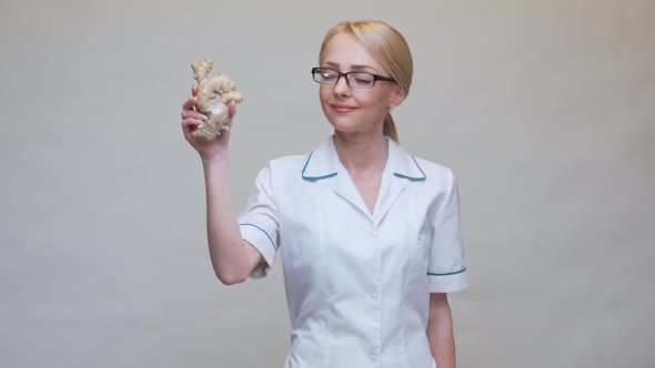 Nutritionist Doctor Healthy Lifestyle Concept - Holding Ginger Root and Jar of or Vitamine Pills alt