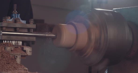 Artist creating a buddhist prayer wheel on a lathe alt