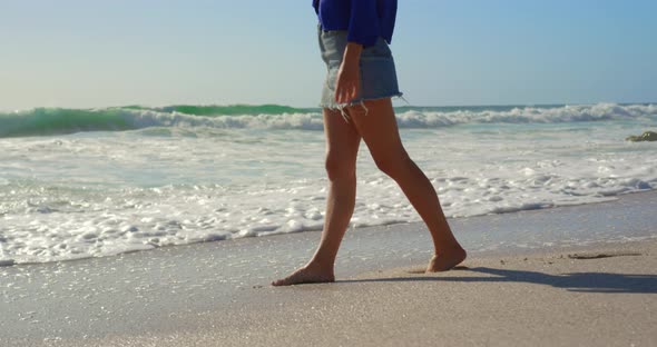 Woman walking on beach in the sunshine 4k