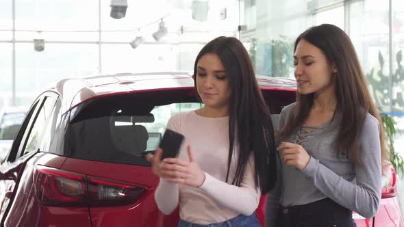 Cheerful Female Friends Taking Selfies Near the New Car  alt
