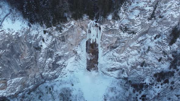 Drone view of frozen waterfall with some water running through