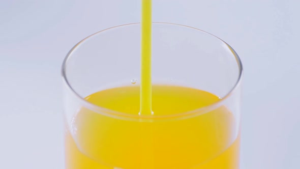 Close Up of Drinking Orange Soda with a Straw at White Background