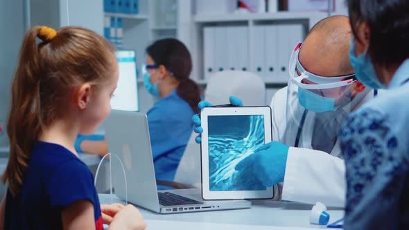 General Practitioner Presenting X-ray of Neck alt