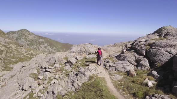 Aerial Above View of Young Woman Hiking or Nordic Walking in Trail Path on Italy Alps Mountains in alt