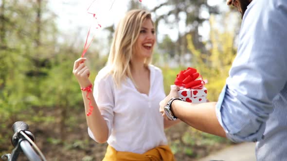 Man Standing and Holding White Surprise Gift Box Behind His Back alt